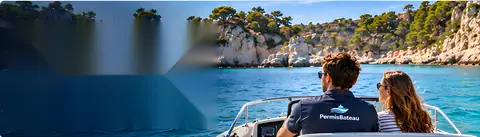 Un couple à la proue d'un bateau devant une crique turquoise
